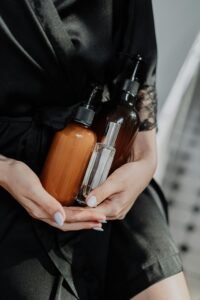 SKINUME A woman in a black silk robe holds eco-friendly cosmetic bottles, highlighting zero waste lifestyle.